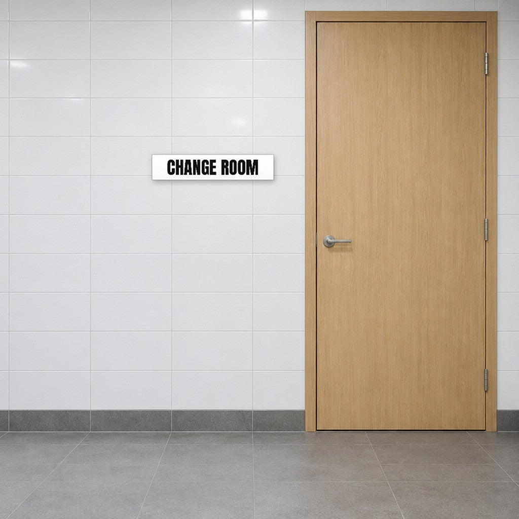 White and black Change Room sign on the wall beside a change room door in an Australian gym