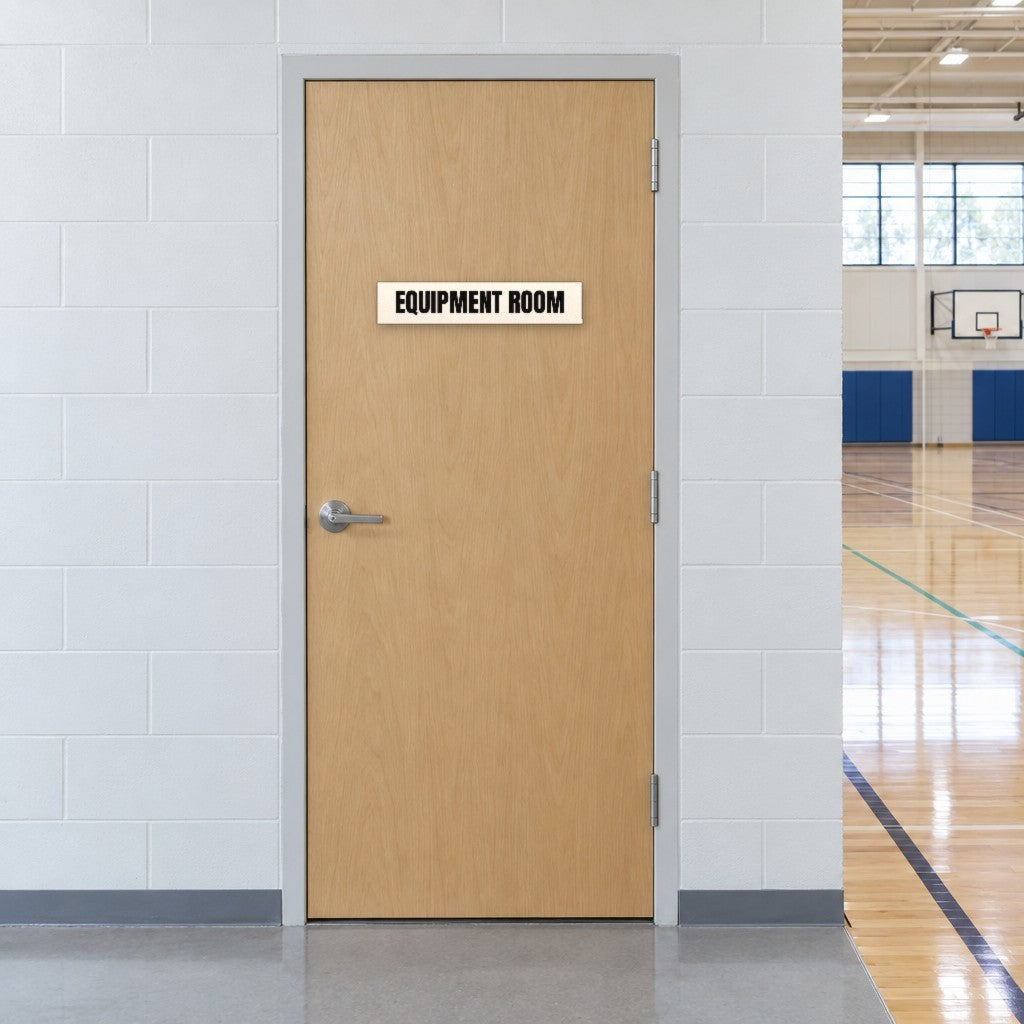 White and black Equipment Room sign on an equipment room door beside an Australian school gymnasium
