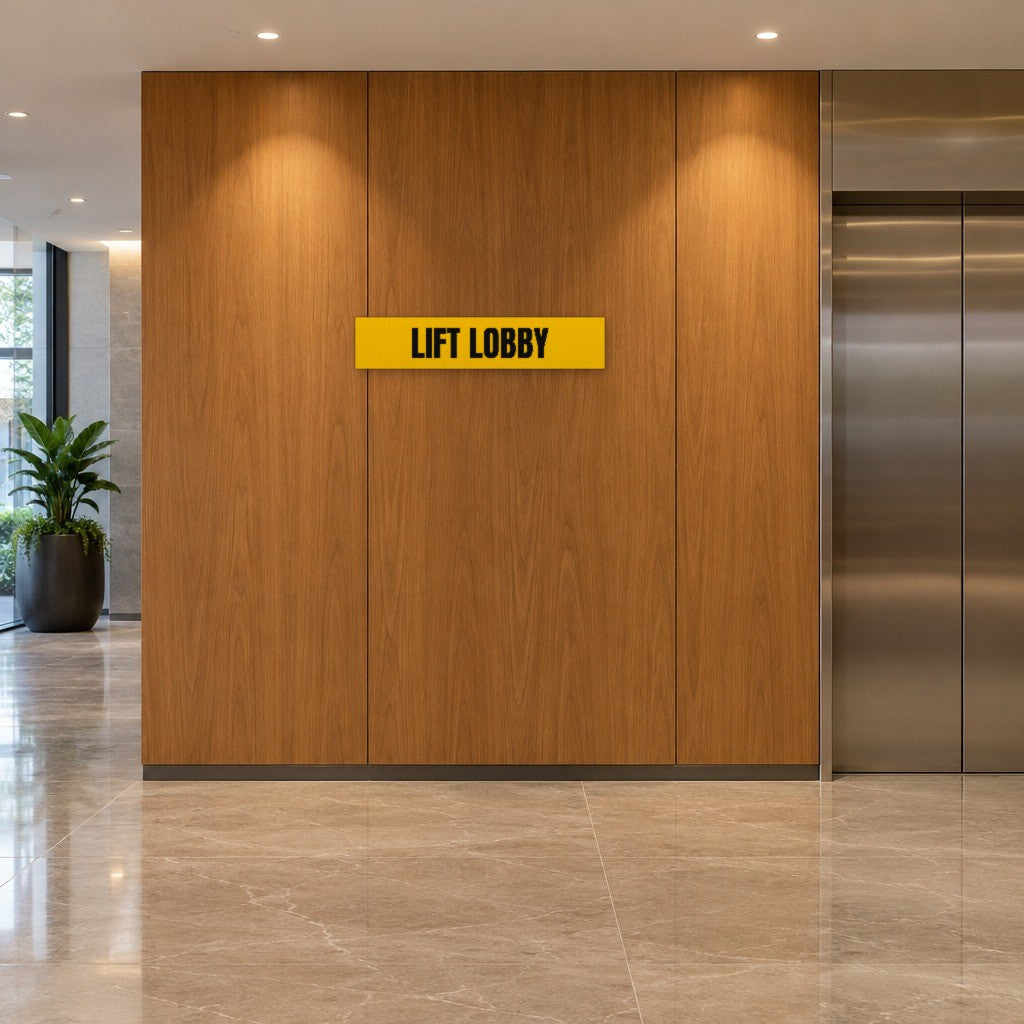 Yellow and black Lift Lobby sign on the timber wall beside the lifts in an Australian apartment building lobby