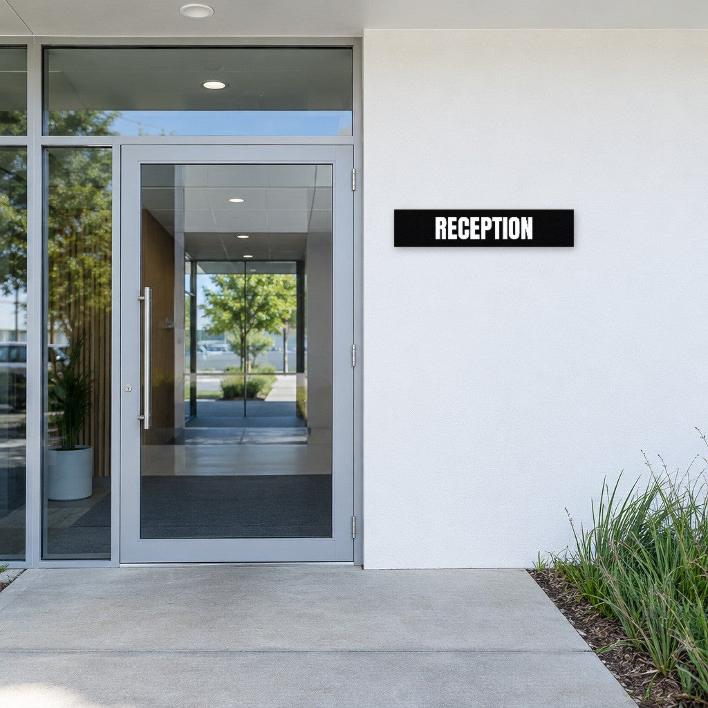 Black and white Reception sign beside the entry door of an Australian office building