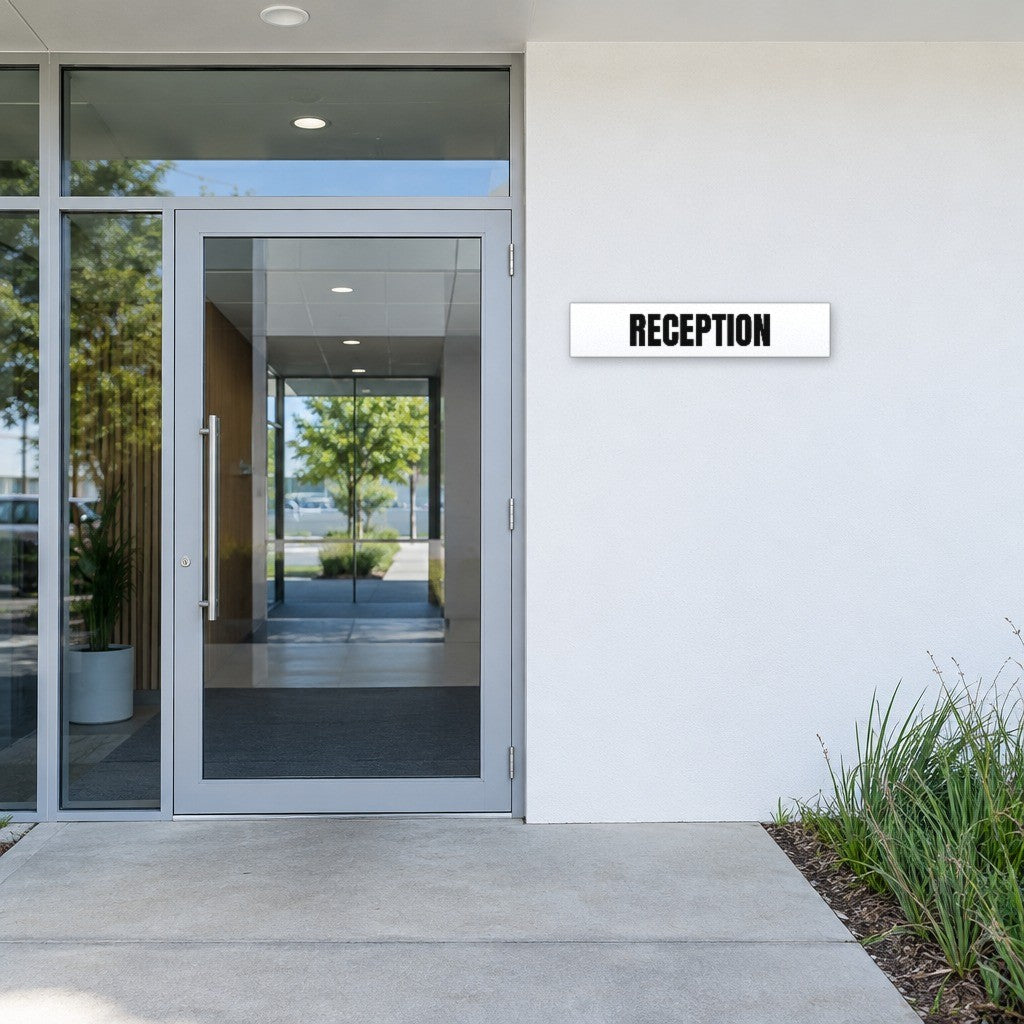 White and black Reception sign beside the entry door of an Australian office building