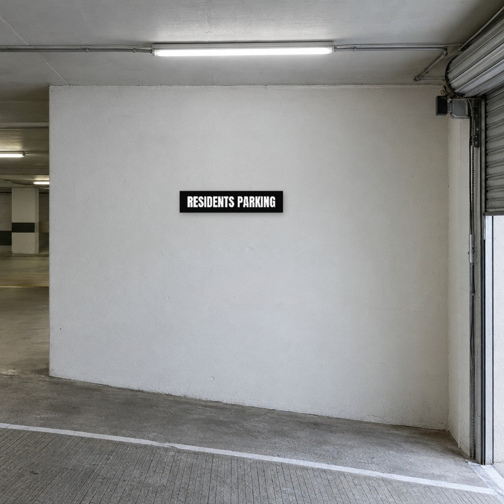 Black and white Residents Parking sign on the wall at the entry to residents parking in an Australian basement car park