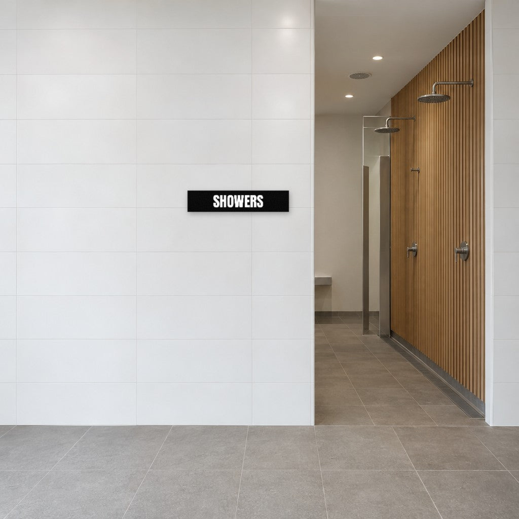 Black and white Showers sign on the tiled wall beside the showers in an Australian end-of-trip facility