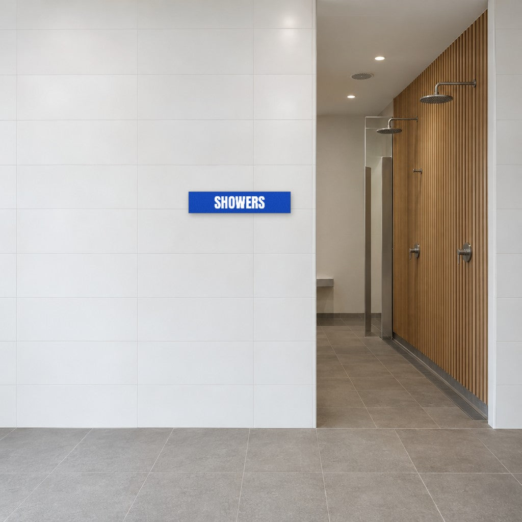Blue and white Showers sign on the tiled wall beside the showers in an Australian end-of-trip facility