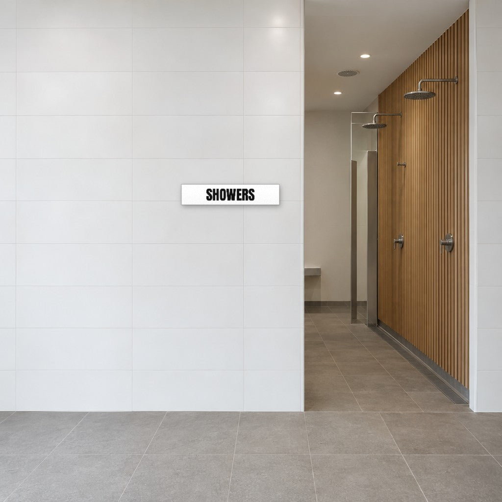 White and black Showers sign on the tiled wall beside the showers in an Australian end-of-trip facility