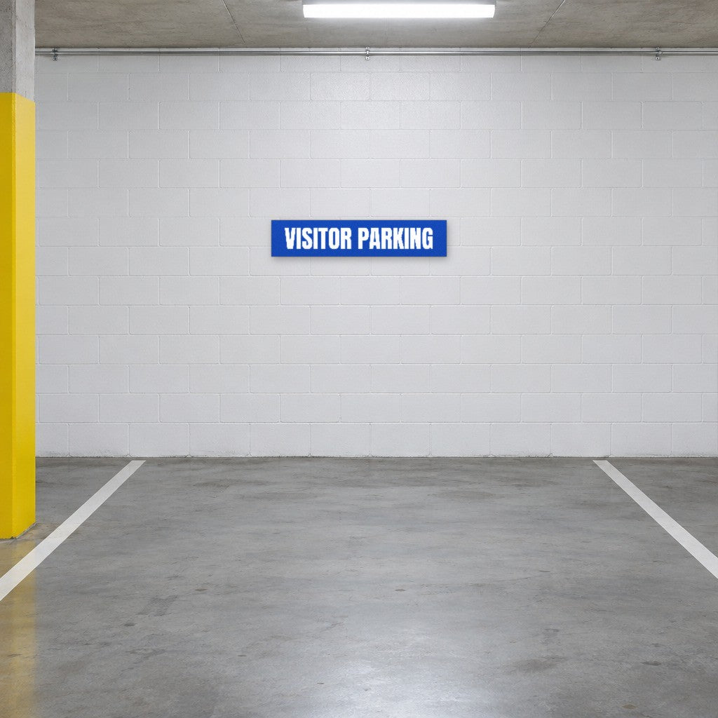 Blue and white Visitor Parking sign on the wall of a visitor parking bay in an Australian basement car park